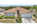 Charming home with lush landscaping, a well-maintained lawn, and a welcoming two-car garage at 24504 Buckingham Way, Punta Gorda, FL 33980