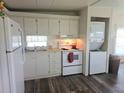 Functional kitchen featuring a refrigerator, stove, and convenient washer/dryer combo at 326 Trailorama Dr, North Port, FL 34287