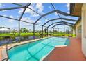 A screened-in pool overlooks a serene pond, offering a private and relaxing outdoor space at 37 Marker Rd, Rotonda West, FL 33947
