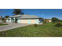 Charming, light blue single-story home with manicured lawn and two-car garage at 39 Norman St, Port Charlotte, FL 33954