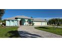Charming, light blue single-story home with manicured lawn and paver driveway for curb appeal at 39 Norman St, Port Charlotte, FL 33954