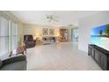 Bright living room featuring tile floors, ceiling fans, and comfortable seating arrangements at 475 Whippoorwill Dr, Venice, FL 34293