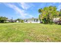 Well-maintained single-story home showcasing lush green lawn, mature tree and landscaping at 769 Crestview Nw Cir, Port Charlotte, FL 33948