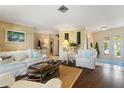 Inviting living room featuring a neutral color palette, hardwood floors, and abundant natural light from the front door at 825 Via Tunis, Punta Gorda, FL 33950