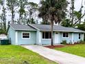Inviting single-story home with a well-manicured lawn and a long concrete driveway leading to the entrance at 15090 Rebecca Ave, Port Charlotte, FL 33953