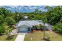 Single-story home featuring well-maintained landscaping, a metal roof and an attached garage at 732 Haleybury St, Port Charlotte, FL 33948