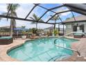 Inviting screened-in pool area with lush landscaping and tranquil water views, perfect for relaxation and entertaining at 8178 Arlewood Cir, Port Charlotte, FL 33981