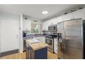 Bright kitchen with white cabinets, stainless steel appliances, butcher block island, and modern backsplash at 915 Beach Rd # 215, Siesta Key, FL 34242