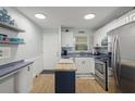 Well-lit kitchen featuring stainless steel appliances, butcher block island, and tile backsplash at 915 Beach Rd # 215, Siesta Key, FL 34242
