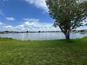 Scenic lake view featuring a lush green lawn, expansive water, and clear skies, showcasing the property's natural beauty at 25225 Rampart Blvd # 502, Punta Gorda, FL 33983