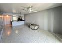 Bright living room featuring tile floors, a ceiling fan, and an open concept layout with view into the kitchen at 25225 Rampart Blvd # 502, Punta Gorda, FL 33983