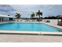 Community pool with palm trees and lounge chairs offering a relaxing atmosphere at 25225 Rampart Blvd # 502, Punta Gorda, FL 33983