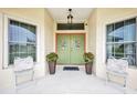 A welcoming front entrance with a decorative double door, potted plants, and seating to enjoy the outside air at 860 Silver Springs Nw Ter, Port Charlotte, FL 33948