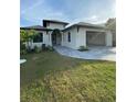 Modern home with attached garage and landscaped front yard at 124 Hercules Dr, Rotonda West, FL 33947