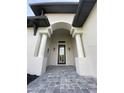 Elegant entryway with arched entry and paver walkway at 124 Hercules Dr, Rotonda West, FL 33947