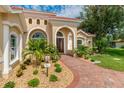 Inviting entryway with walkway, landscaping, and a double door entry at 8074 Wiltshire Dr, Port Charlotte, FL 33981