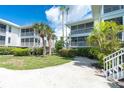 View of condo building, tropical landscaping, and courtyard at 7446 Palm Island Dr # 3514, Placida, FL 33946
