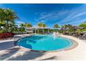 Community pool with lounge chairs at 10540 Amberjack Way # 302, Englewood, FL 34224