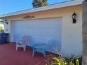 Attached garage with seating area and outdoor lighting at 745 Coral Way, Englewood, FL 34223