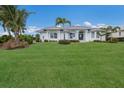 White house with metal roof, landscaping, and palm trees at 495 Coral Creek Dr, Placida, FL 33946