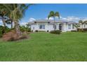 White house with metal roof, landscaping, and palm trees at 495 Coral Creek Dr, Placida, FL 33946