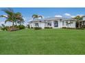 White house with metal roof, landscaping, and palm trees at 495 Coral Creek Dr, Placida, FL 33946