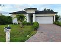 Single-story home with a white exterior and landscaped yard at 118 Green Pine Park, Rotonda West, FL 33947