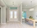 Bright entryway with double doors, dining area, and wood-look floors at 777 Boundary Blvd, Rotonda West, FL 33947