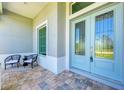 Front entry with teal double doors, tile flooring, and two chairs at 777 Boundary Blvd, Rotonda West, FL 33947