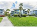 Two-story building with light-colored siding, balconies, and lush landscaping at 7454 Palm Island Dr # 3313, Placida, FL 33946