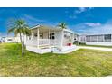 Mobile home with front porch and landscaped lawn at 337 Blackburn Blvd, North Port, FL 34287