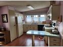 Small kitchen with light wood cabinets and a breakfast bar at 6276 Oriole Blvd, Englewood, FL 34224