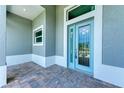 Modern front entry with light blue door and tiled flooring at 9293 Panama Cir, Port Charlotte, FL 33981