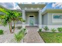 Front entry with walkway, landscaping, and light gray walls at 14999 Wichita Rd, Port Charlotte, FL 33981