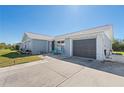 Home's exterior features a well-manicured lawn, driveway, 1-car garage and inviting front porch at 13525 Dibella Ave, Port Charlotte, FL 33981
