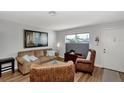 Comfortable living room with light gray walls, neutral sofa, and wicker chairs at 13525 Dibella Ave, Port Charlotte, FL 33981