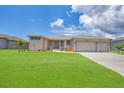 New construction home with a two-car garage and lush lawn at 8343 Olsen St, Port Charlotte, FL 33981