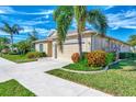 Single story home with attached garage and landscaping at 584 Gadsen St, Englewood, FL 34223