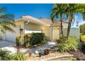 Front view of a house featuring a tan facade and neatly landscaped yard at 28260 Pablo Picasso Dr, Englewood, FL 34223