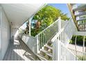 White wooden staircase leading to second floor, surrounded by tropical landscaping at 7450 Palm Island Dr # 3411, Placida, FL 33946