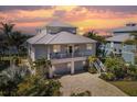 Two-story waterfront home with a metal roof and double-car garage at 13330 Anglers Way, Placida, FL 33946