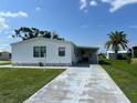 White mobile home with covered patio and driveway at 8485 Nighthawk Dr, Englewood, FL 34224