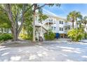 Two-story building with stairs, tropical landscaping, and parking area at 7536 Palm Island S Dr # 1524, Placida, FL 33946