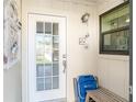Front entry with white door and small bench at 6796 Gasparilla Pines Blvd # 95, Englewood, FL 34224