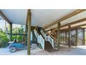 Under-house area with stairs, golf cart, and storage; ample space for parking and storage at 431 Kettle Harbor Dr, Placida, FL 33946