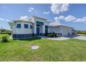 White two-story home with blue accents and a metal roof at 14207 Union Hall Ave, Port Charlotte, FL 33981