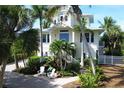 Two story home with lush landscaping and blue door at 201 Kettle Harbor Dr, Placida, FL 33946