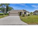 Tan house with a two-car garage and well-manicured lawn at 104 Park Forest Blvd, Englewood, FL 34223