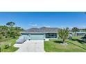 Single-story house with two-car garage and palm tree at 9194 Impala Cir, Port Charlotte, FL 33981