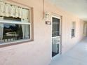 Condo entrance with a screen door and a window overlooking a courtyard at 179 Boundary Blvd # 7, Rotonda West, FL 33947